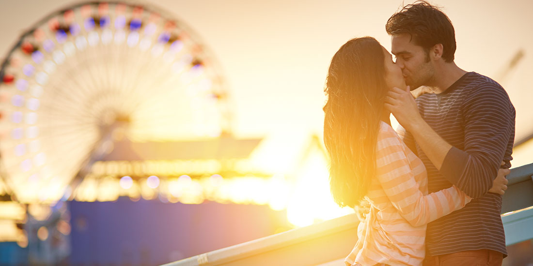 couple kissing near a ferriswheel because they know they find true love