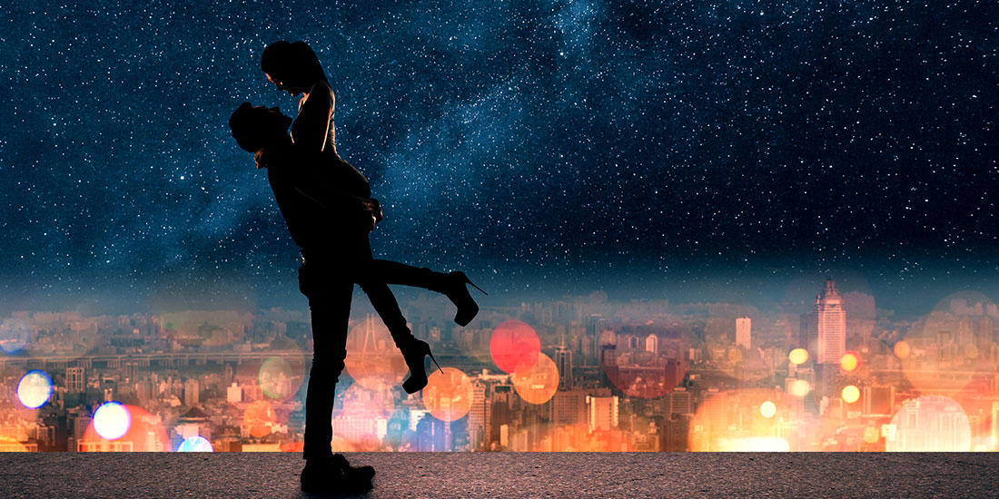 man romantically lifting his woman above in los angeles at night